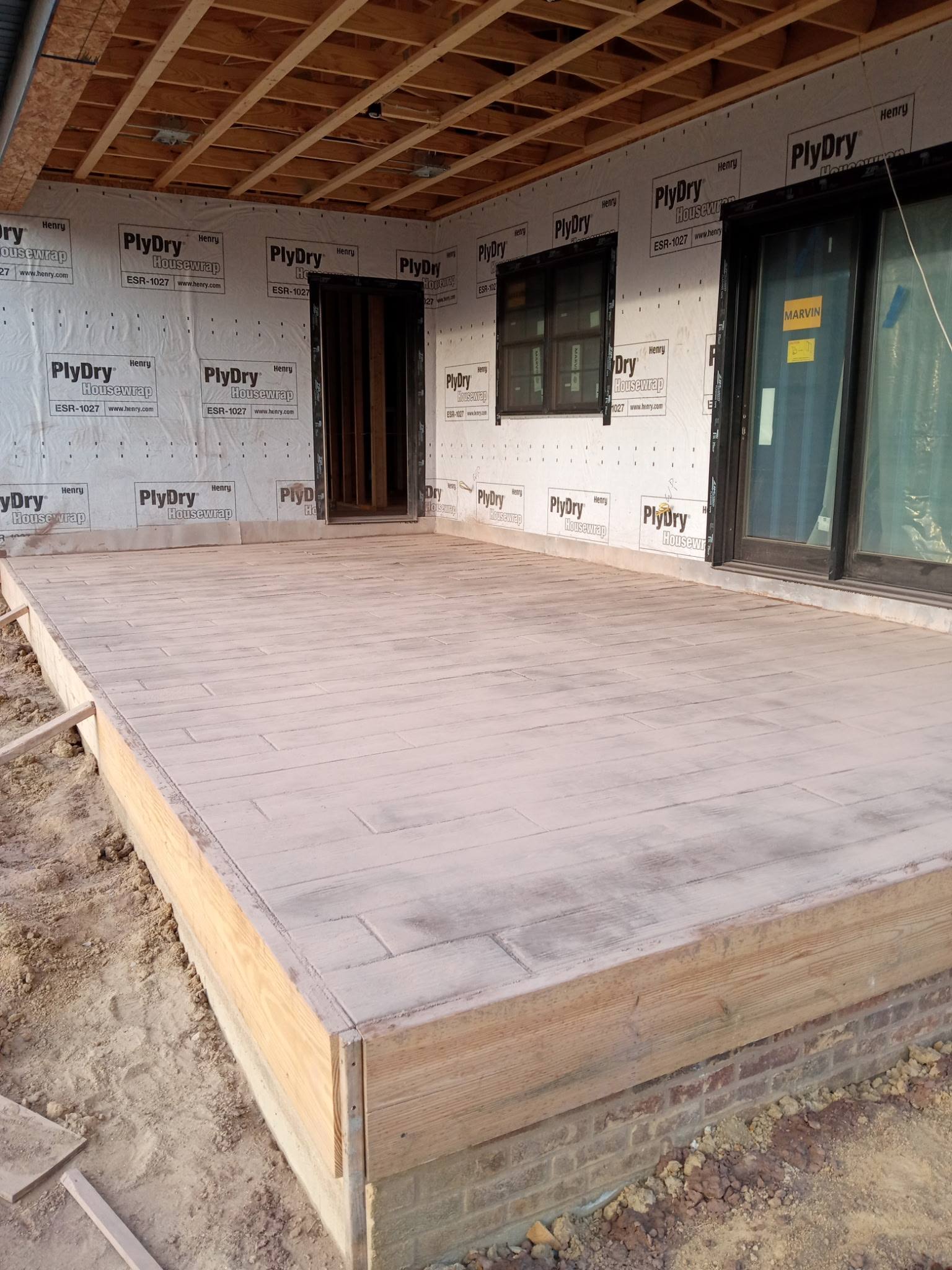 Wide view of wood-plank stamped concrete covered porch