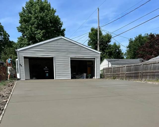 Wide concrete driveway pad in front of a detached garage