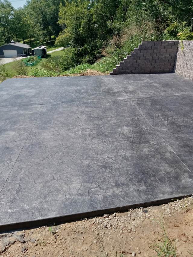 Stamped slate-pattern patio with retaining wall
